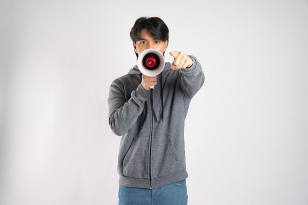 穿着连帽衫的亚洲男性在白色背景前摆姿势的肖像图片下载