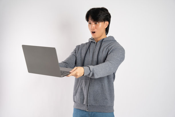 穿着连帽衫的亚洲男子在白色背景前摆姿势的肖像图片下载