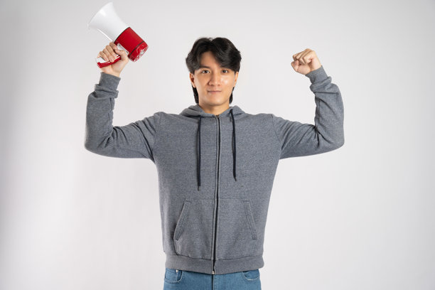 穿着连帽衫的亚洲男子在白色背景前摆姿势的肖像图片下载