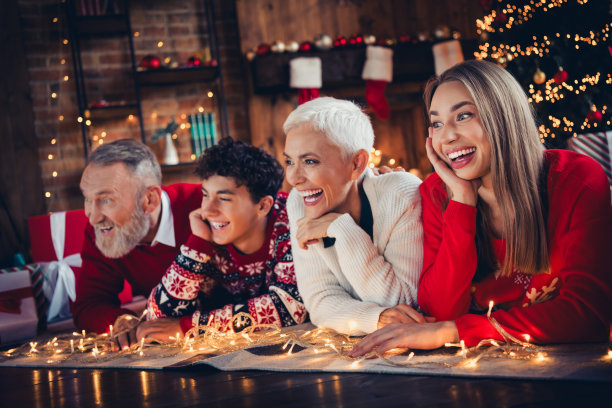 微笑的积极家庭照片，祖母、祖父、孙子和孙女躺在圣诞装饰的房间里欢笑。图片下载