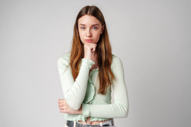 若有所思的棕色长发年轻女人，白色背景图片下载