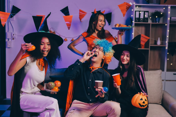 办公室万圣节派对：同事们穿着节日服装，举杯欢笑图片下载