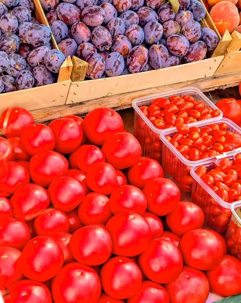 市场上新鲜、明亮的产品有李子、西红柿和草莓。柜台上色彩缤纷的蔬菜和水果组合，竖版。图片下载