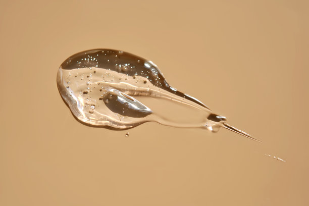 一滴润滑剂或化妆凝胶在米色背景上。图片下载