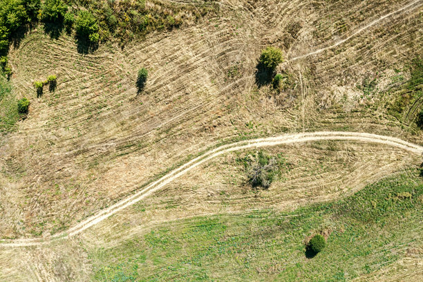 蜿蜒的乡村小路穿过草地。阳光明媚的秋季乡村风景。航拍照片。图片下载