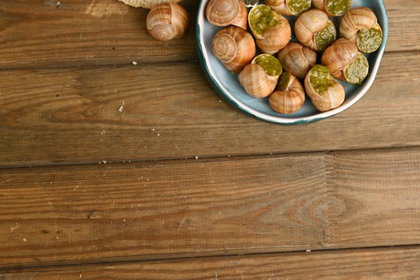 宏观蜗牛与香蒜酱的照片，上面是蜗牛配罗勒香蒜酱、帕尔马干酪和松子。图片下载