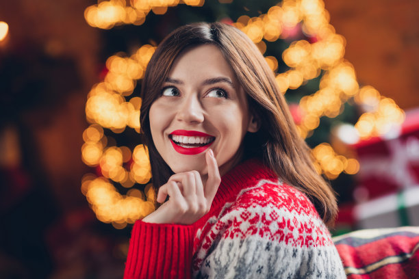 特写肖像照片，年轻可爱的女士穿着舒适的毛衣，满足地凝视着空旷的空间，心中充满幻想，待在室内，感受圣诞氛围。图片下载