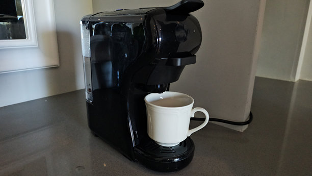 黑色咖啡机在现代厨房中制作一杯热咖啡图片下载