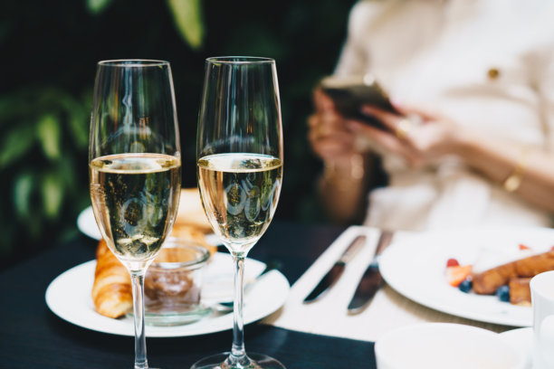 桌子上两只香槟杯，背景是早午餐。图片下载