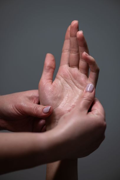 按摩师正在为客户按摩手掌。水疗护理的特写手部照片。竖版照片。图片下载