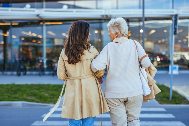 两位女性手挽手走在购物中心附近图片下载