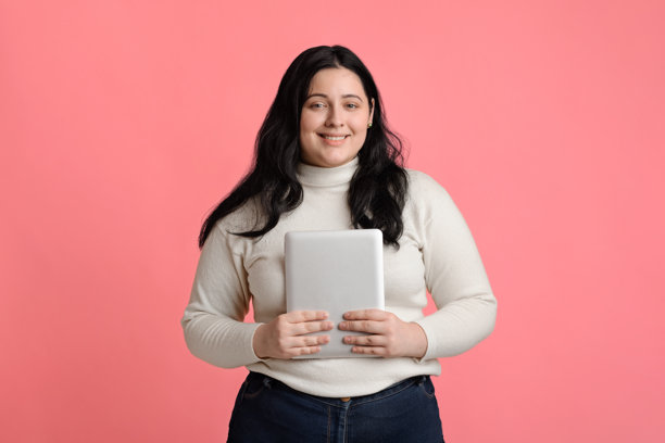 微笑的丰满女孩手持数字平板电脑摆姿势图片下载