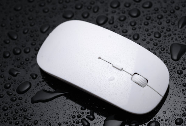 黑色背景上带水滴的白色电脑鼠标图片下载