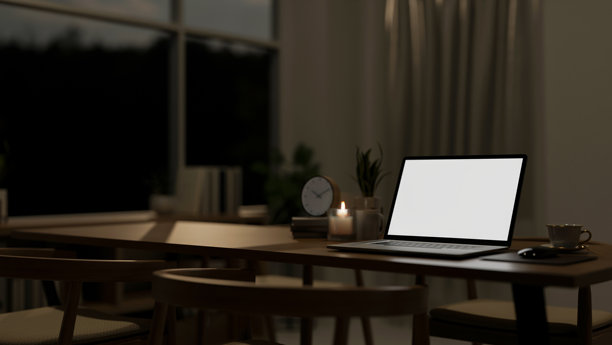 现代餐厅夜晚餐桌上的笔记本电脑模型特写。图片下载