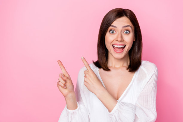 漂亮年轻女性的照片肖像，展示广告空间，令人难以置信的销售，穿着时尚的白色服装，背景为粉色。图片下载