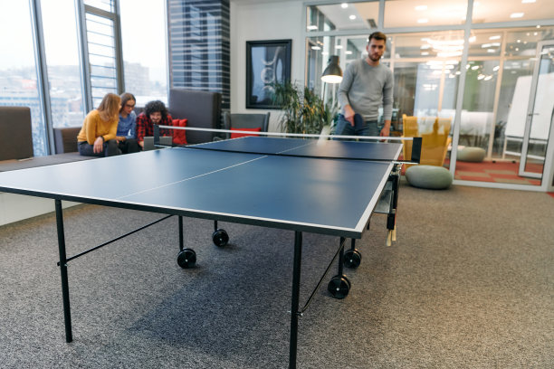 商务同事们暂时离开工作，享受乒乓球比赛，促进团队合作和同事情谊。图片下载