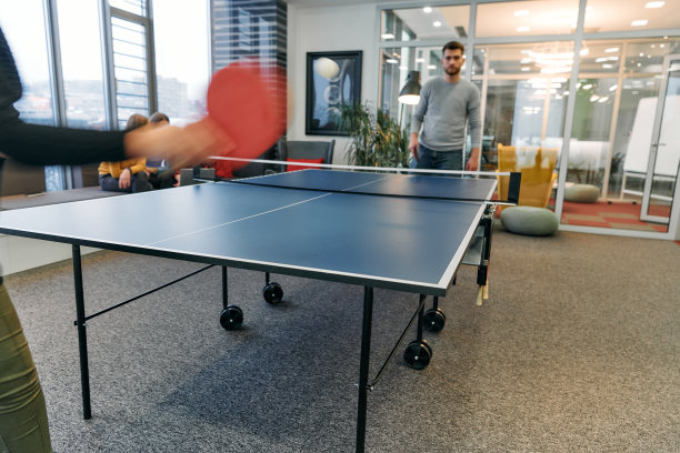 商务同事们暂时离开工作，享受乒乓球游戏，促进团队合作和同事情谊。图片下载