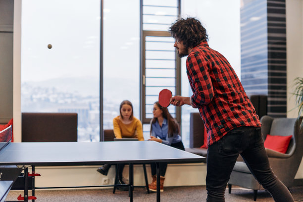 商务同事们暂时离开工作，享受乒乓球比赛，促进团队合作和同事情谊。图片下载