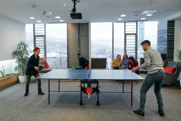 商务同事们暂时离开工作，享受乒乓球游戏，促进团队合作和同事情谊。图片下载