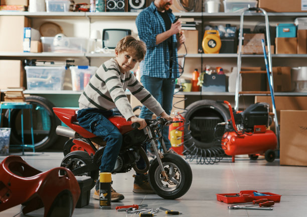 父亲在车库检查儿子的摩托车图片下载