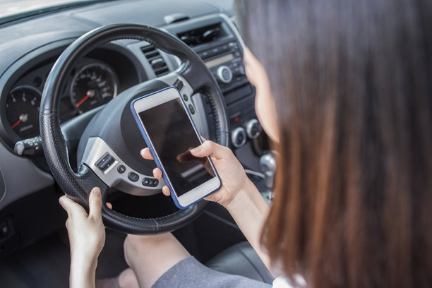 在车里看智能手机的女人图片下载