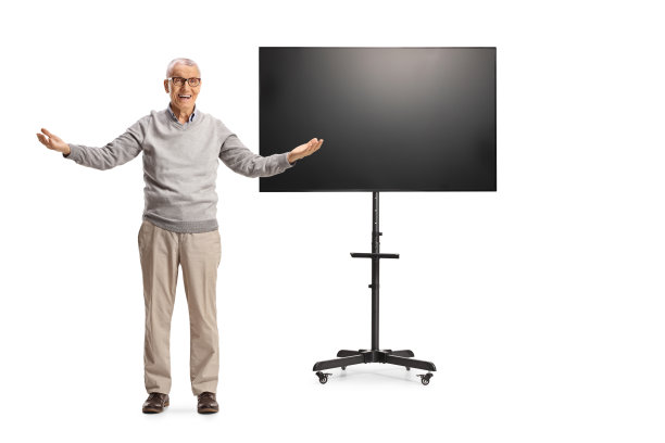 年长的绅士站在电视机前，张开双臂图片下载