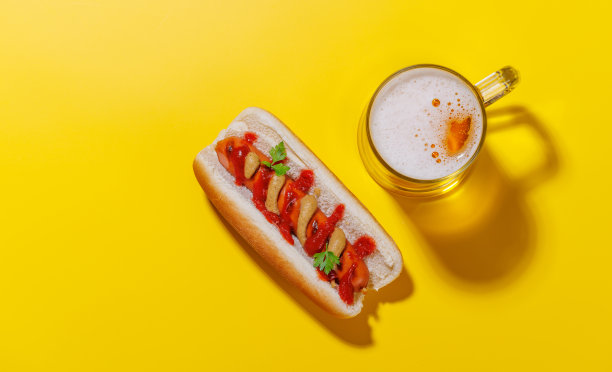 一张生动的照片展示了一杯啤酒和经典热狗图片下载