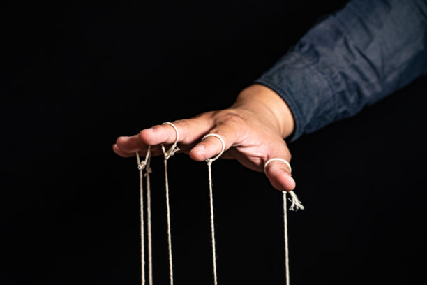 男人用手指控制木偶的特写，操纵概念图片下载