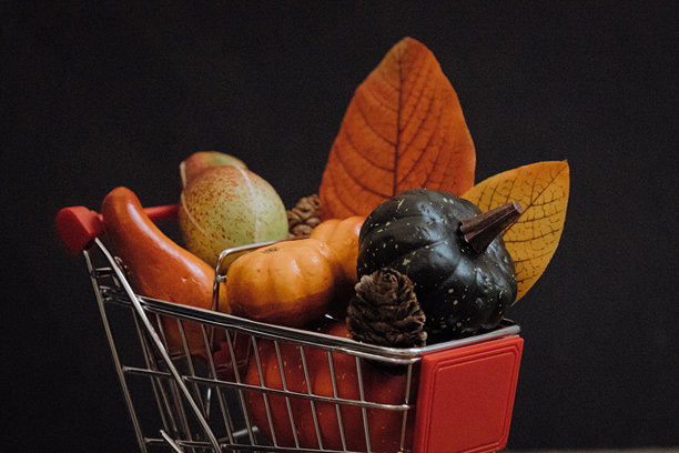 购物车里的南瓜，锥形物和叶子在黑色背景上。图片下载