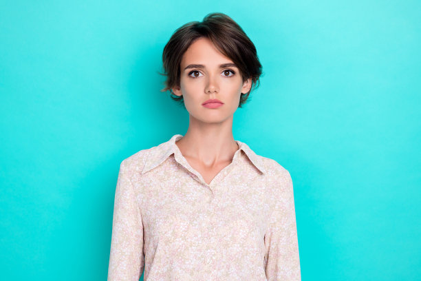 特写照片：年轻迷人、漂亮、严肃的女性，作为企业家和商业拥有者，背景为青色。图片下载
