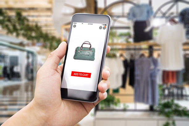 拿着手机在购物中心服装店网上购物图片下载