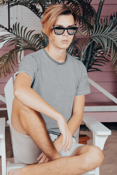 海上假期：在海滩上拿着冲浪板的年轻有魅力的男人图片下载