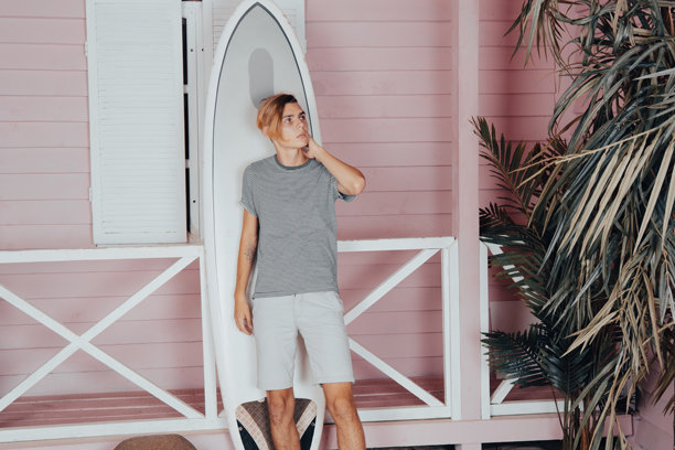 海上假期：在海滩上拿着冲浪板的年轻有魅力的男人图片下载