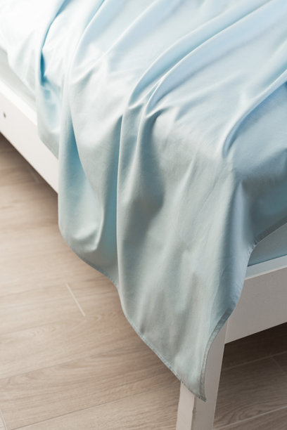 一块随意放在床上的蓝色棉床单。特写，微距照片。极简主义卧室。舒适的家居概念。斯堪的纳维亚风格。图片下载