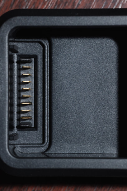 电池充电器接触点黑色塑料设备框架垂直放置在桌子上图片下载