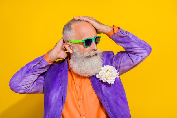 侧面肖像照片，展示一位迷人的古怪男子，发型独特，穿着鲜艳的服装，准备在夜总会放松，背景为黄色。图片下载