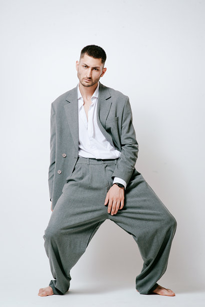 穿着灰色西装、赤脚的时尚男模特，在摄影棚拍摄图片下载