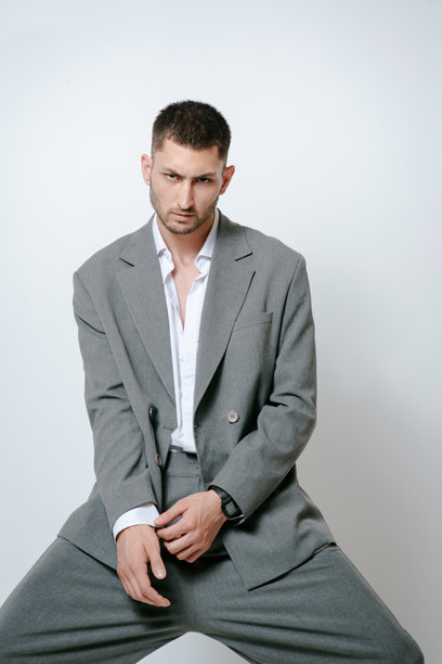 穿着灰色西装的时尚男模特，在摄影棚拍摄图片下载