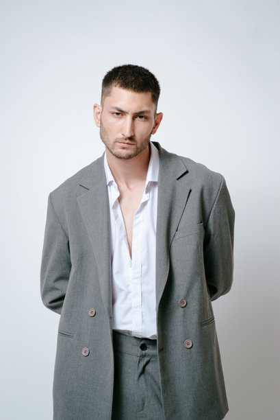 穿着灰色西装的时尚男模特，在摄影棚拍摄图片下载