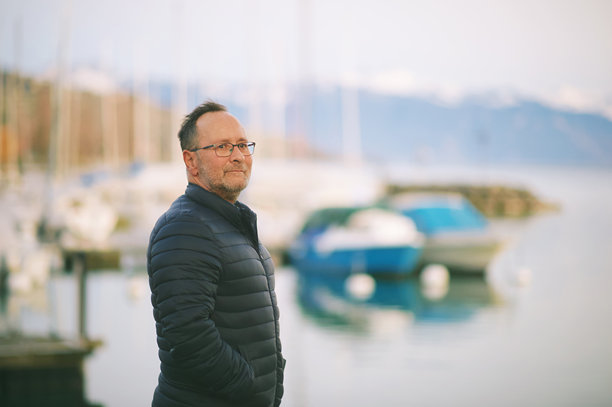 50至55岁男子在户外享受美丽湖景的肖像图片下载