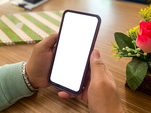 手握空白屏幕的手机在办公室。手机模型。图片下载