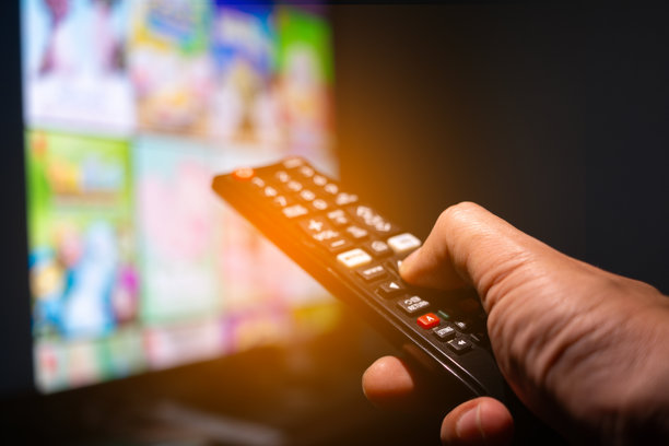 人手里拿着遥控器，多媒体、在线电视，向家里的观众播放娱乐节目。广播背后的想法图片下载