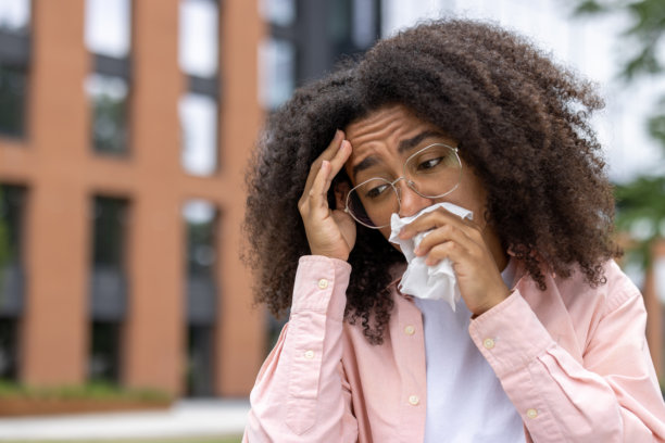 在大学校园外感冒不适的年轻女学生拿着纸巾图片下载