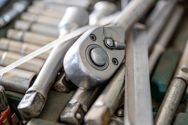 男人车库中各种必要工具和零件的特写照片。汽车检查和汽车服务店的概念。各种类型的工具，特别是扳手。图片下载