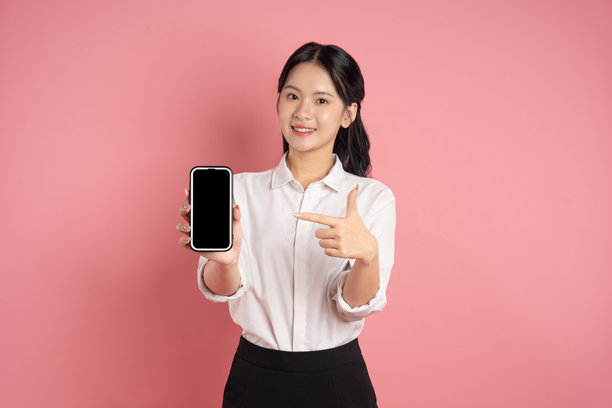 亚洲女商人在粉色背景前摆姿势的肖像图片下载