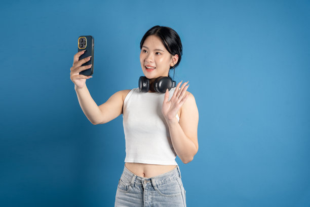 美丽的亚洲女性在蓝色背景前摆姿势的肖像图片下载