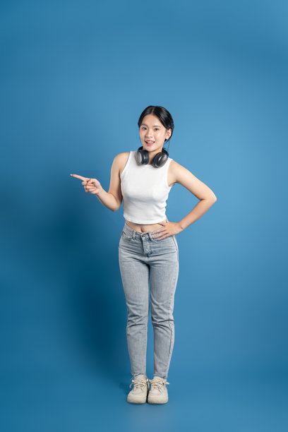 美丽的亚洲女性在蓝色背景前摆姿势的肖像图片下载