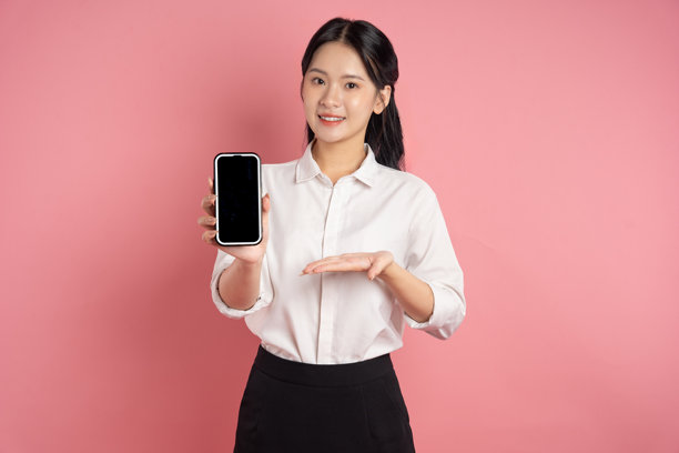 亚洲女商人在粉色背景前摆姿势的肖像图片下载