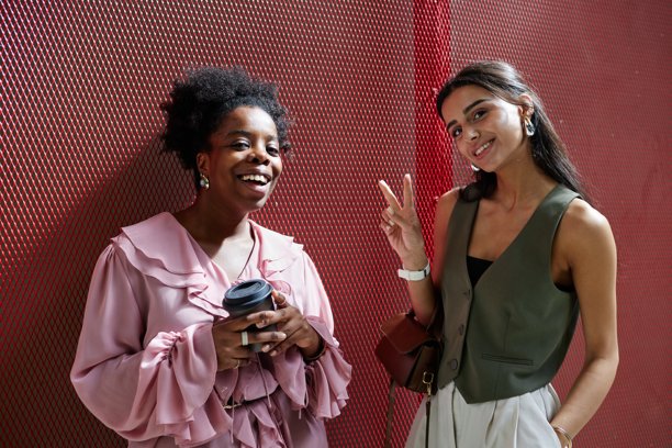 两位微笑的女商人在办公中心的红色格子背景前合影图片下载