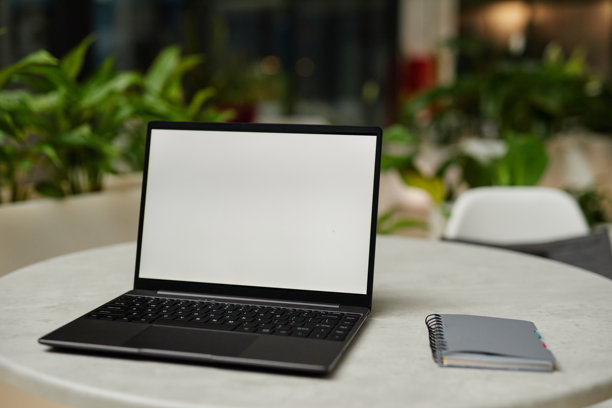 咖啡馆桌子上带有样机屏幕的笔记本电脑图片下载
